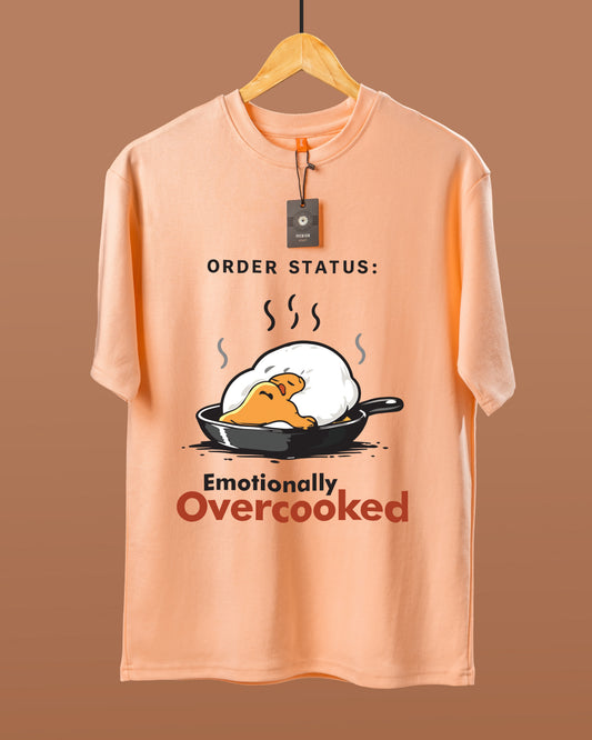 DUMM Emotionally Overcooked oversized t-shirt in peach on wooden hanger