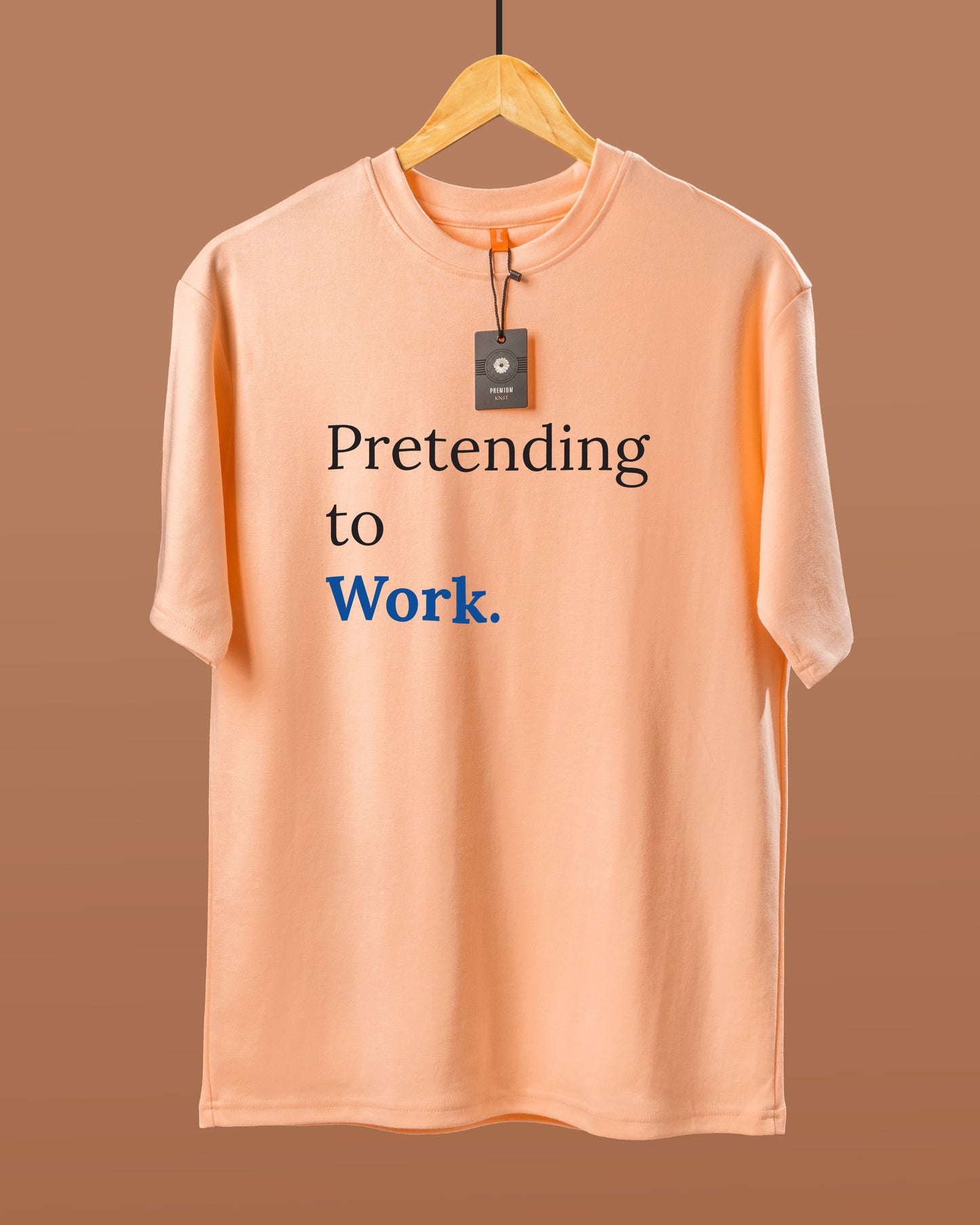 DUMM Pretending To Work oversized t-shirt in peach on wooden hanger