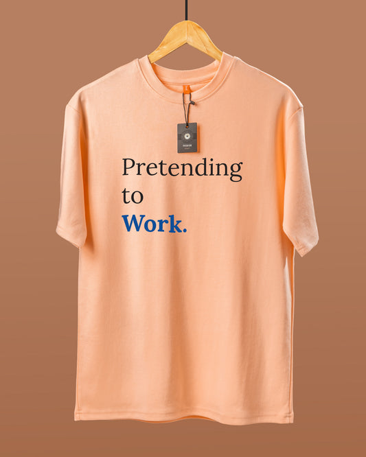 DUMM Pretending To Work oversized t-shirt in peach on wooden hanger