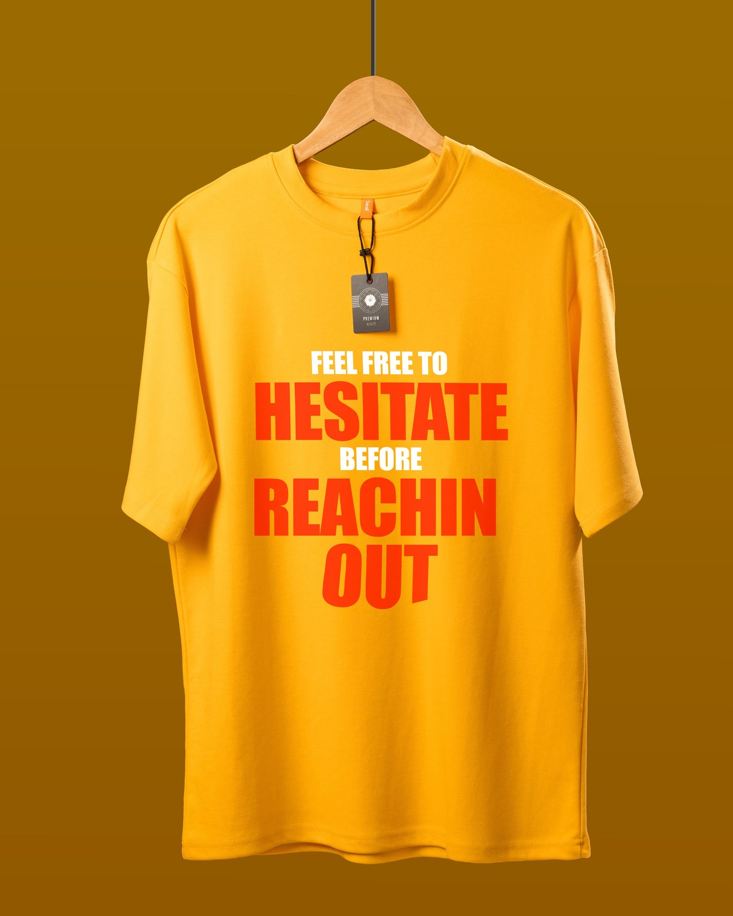 DUMM Feel Free To Hesitate Before Reachin Out oversized t-shirt in mustard yellow on wooden hanger