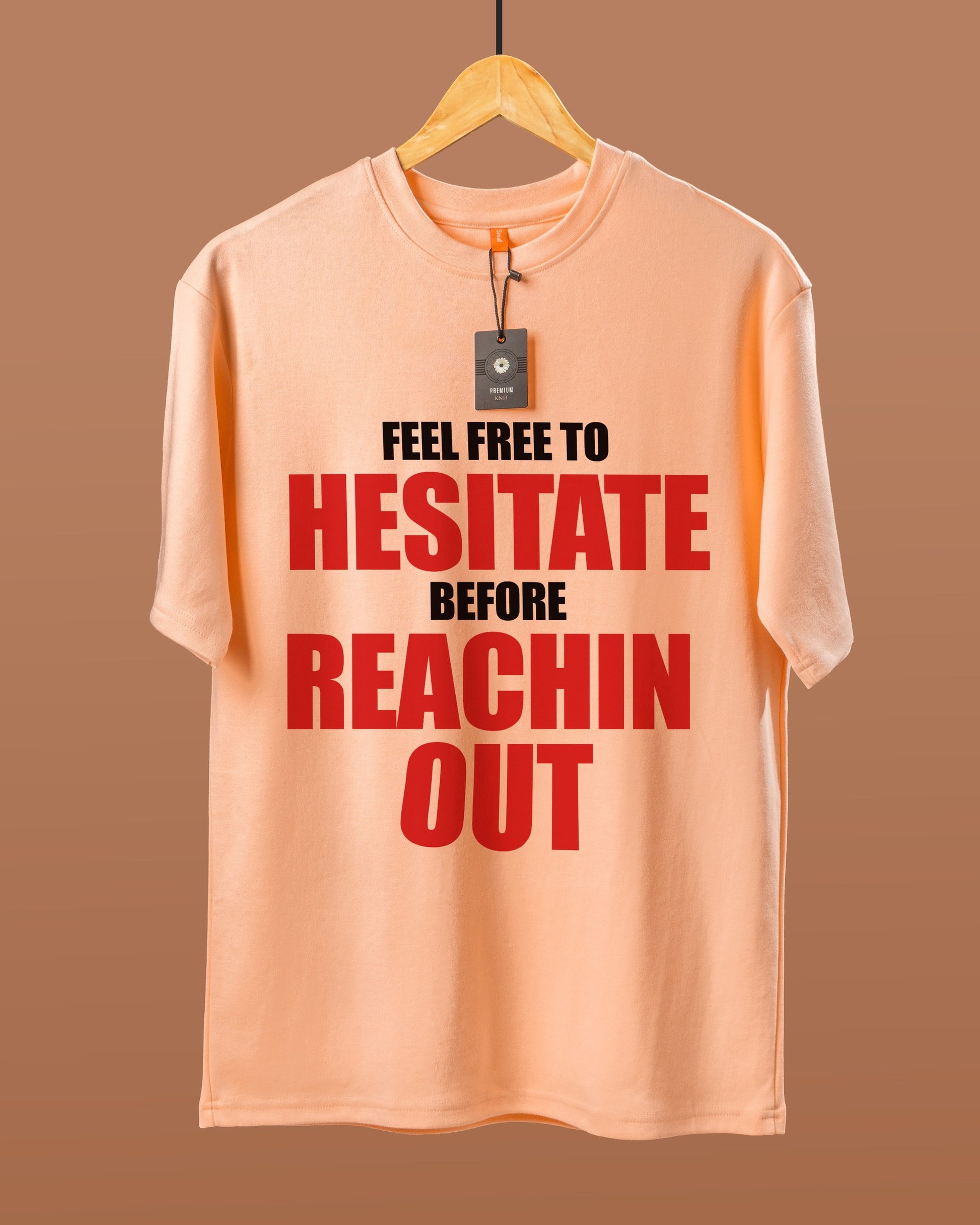 DUMM Feel Free To Hesitate Before Reachin Out oversized t-shirt in peach on wooden hanger