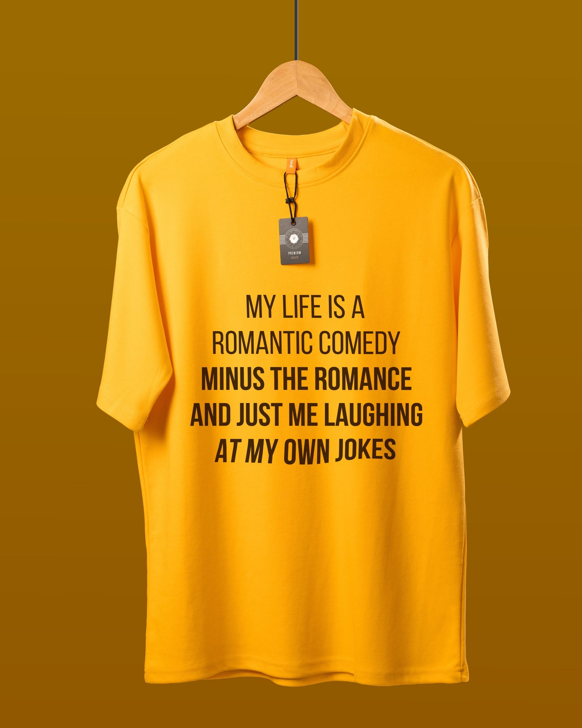 DUMM Romantic Comedy Minus The Romance oversized t-shirt in mustard yellow on wooden hanger